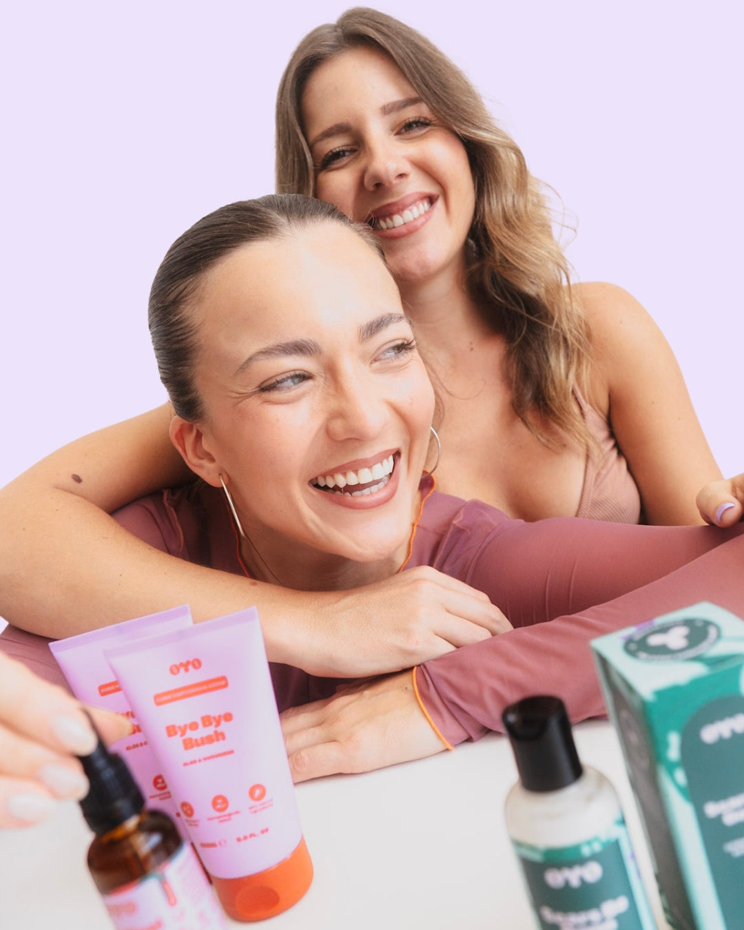 Two smiling women showcasing natural skincare products, promoting irritation-free routines and soft, nourished skin.
