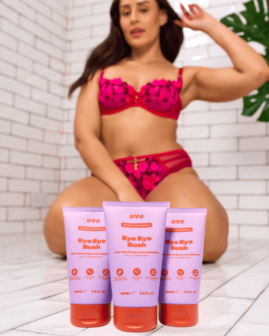 Woman in pink bikini sitting on a floor with three Bye Bye Bush in front of her.